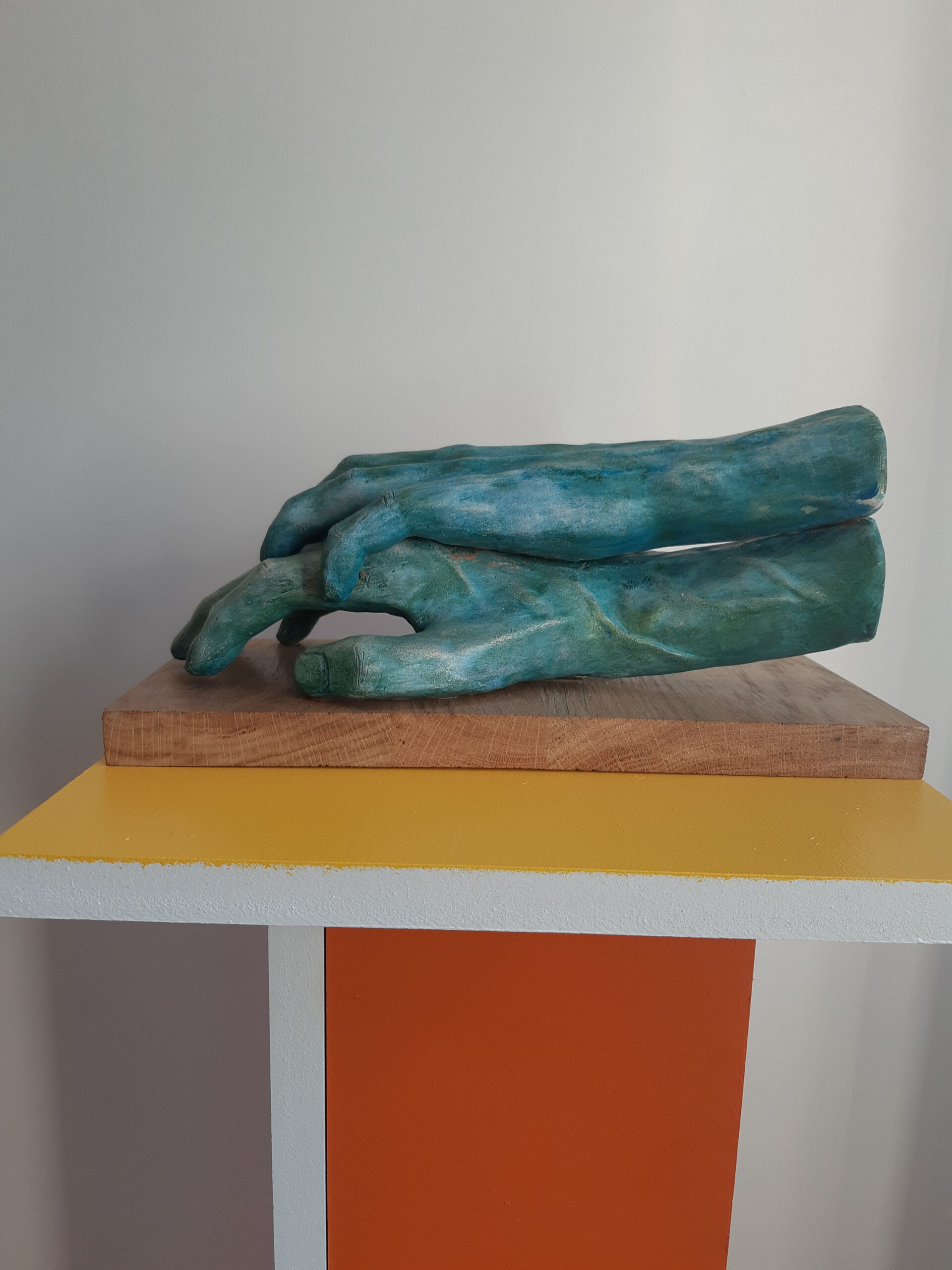 Sculpture de Patrick Voisin en terre cuite, patine à la peinture acrylique, représentant la main gauche d'une femme posée à plat sur la main droite d'un homme. Vue latérale gauche.