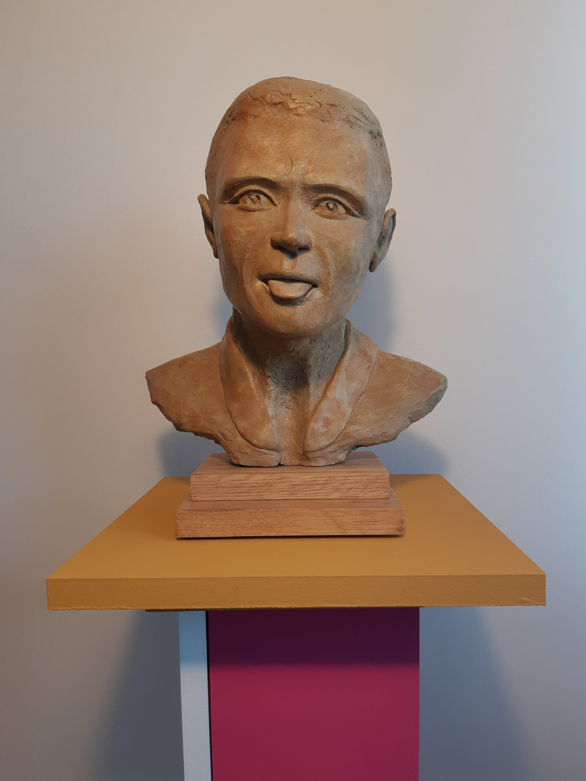 Sculpture patinée de Patrick Voisin représentant la tête d'un homme tirant la langue.
